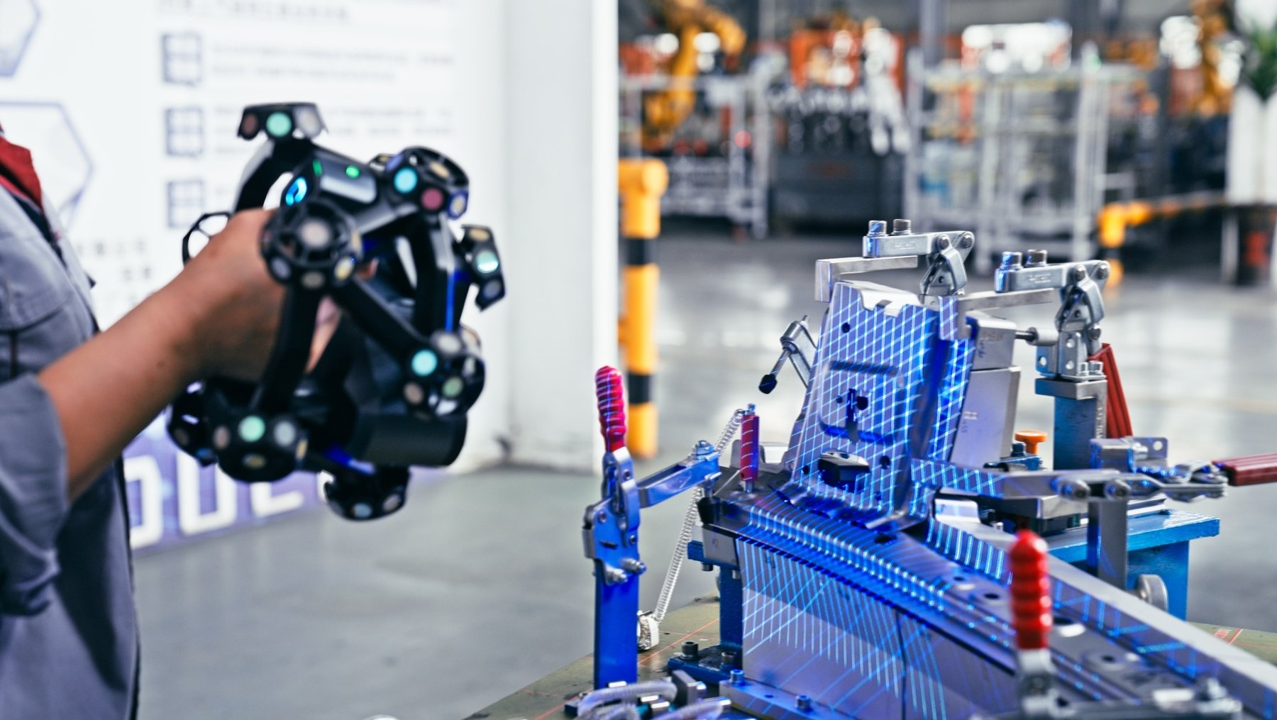 An engineer inspecting an automotive sheet metal panel with a handheld metrology 3D scanner and a dynamic tracking system